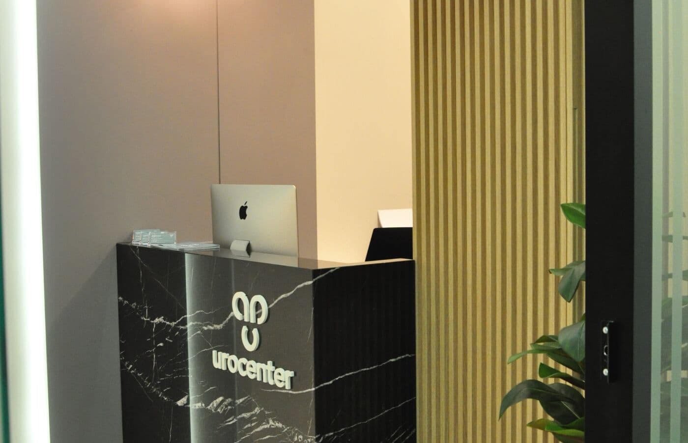Recepção da Urocenter com balcão em mármore preto e o logotipo da clínica